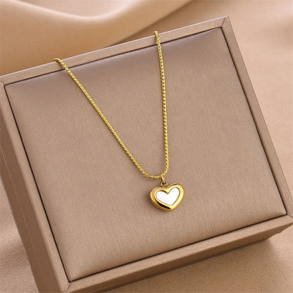 Gold heart-shaped necklace on a beige box